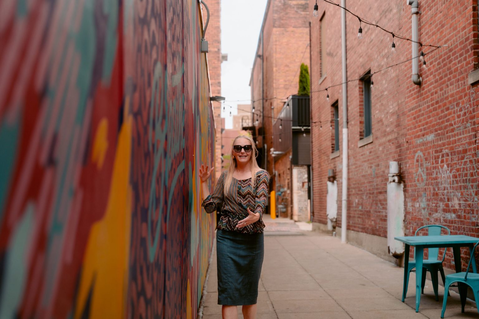 Alexandra Hall walking through a Fort Wayne muraled alley